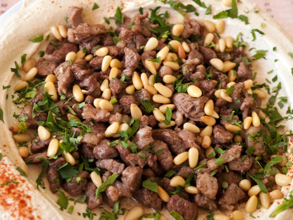 hummus served with lamb and pine nuts