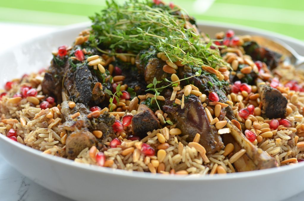 arabian nut rice with lamb shanks served in a white bowl