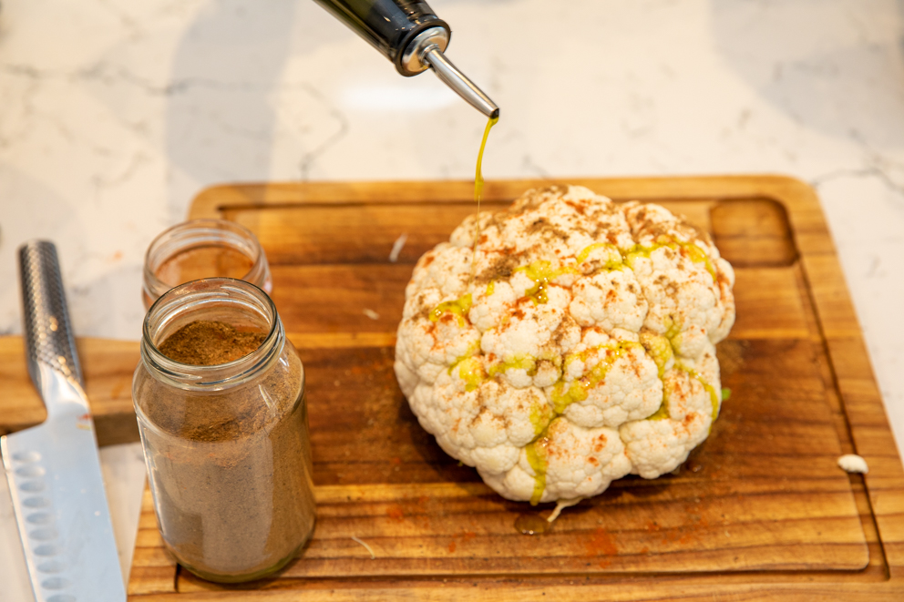 drizzling oil over the cauliflower