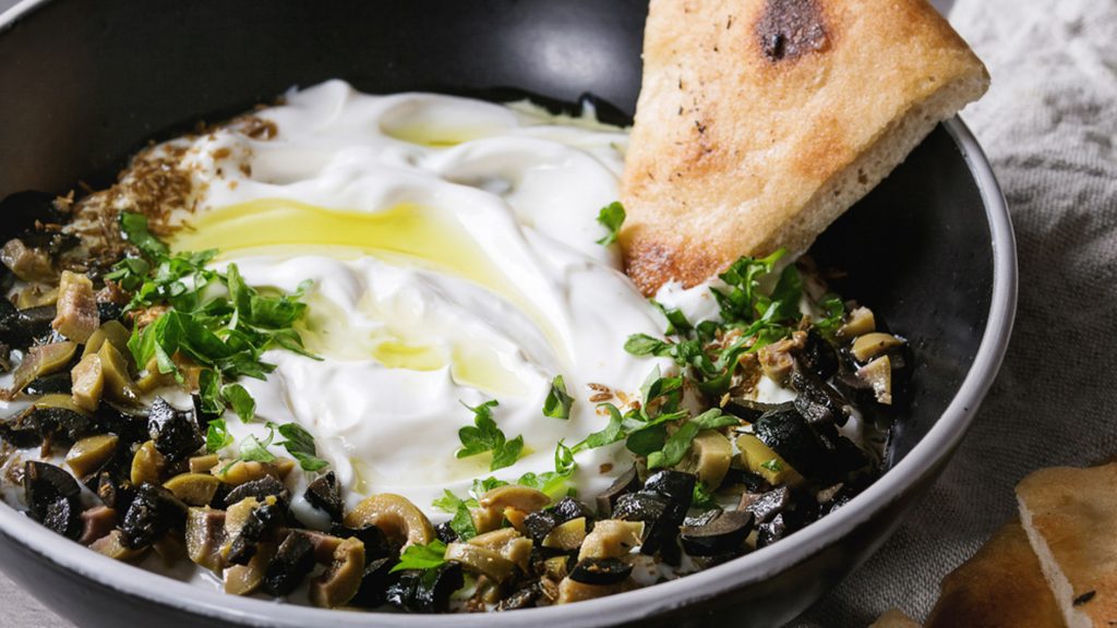 Labneh dip recipes - Strained Yogurt served in a bowl and garnished with chopped olives