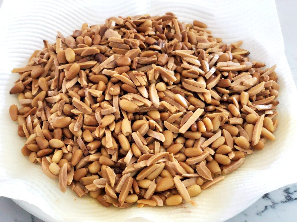 fried pine nuts and almonds on paper towel