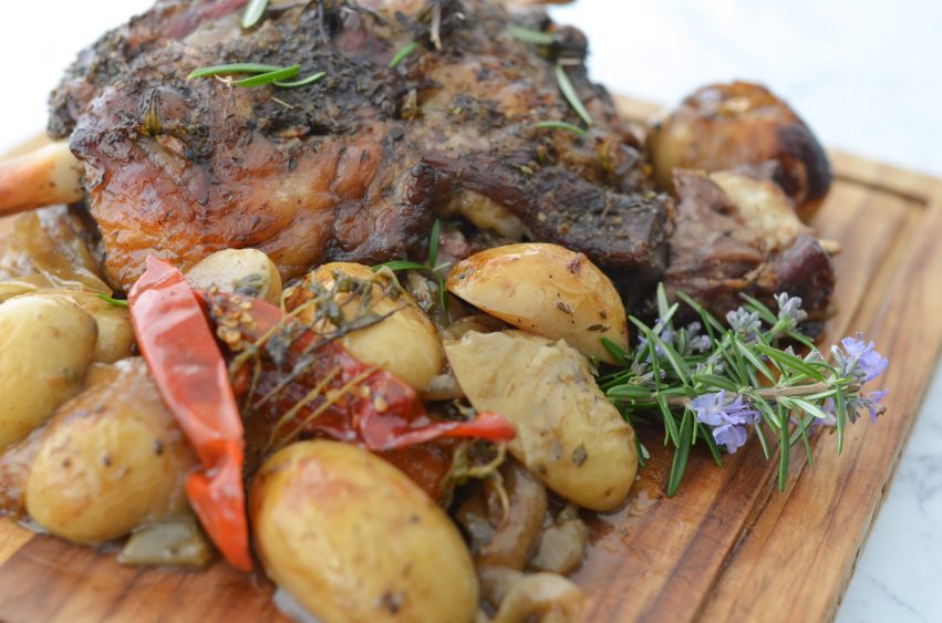 lamb roast with roast potatoes served on a wooden board