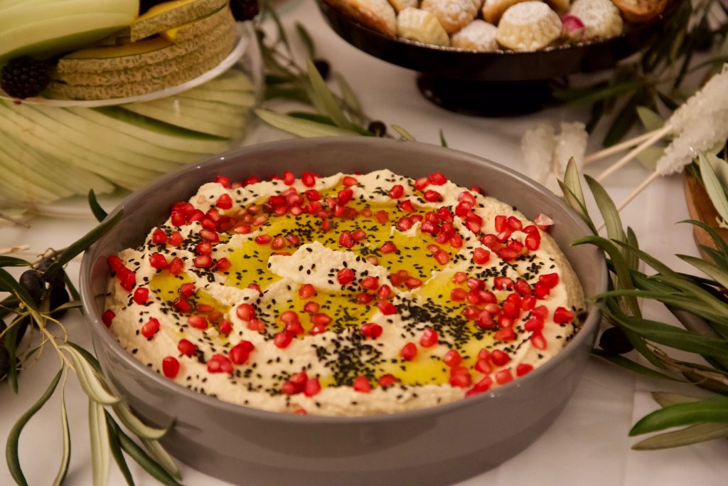 hummus garnished with black sesame and pomegranate