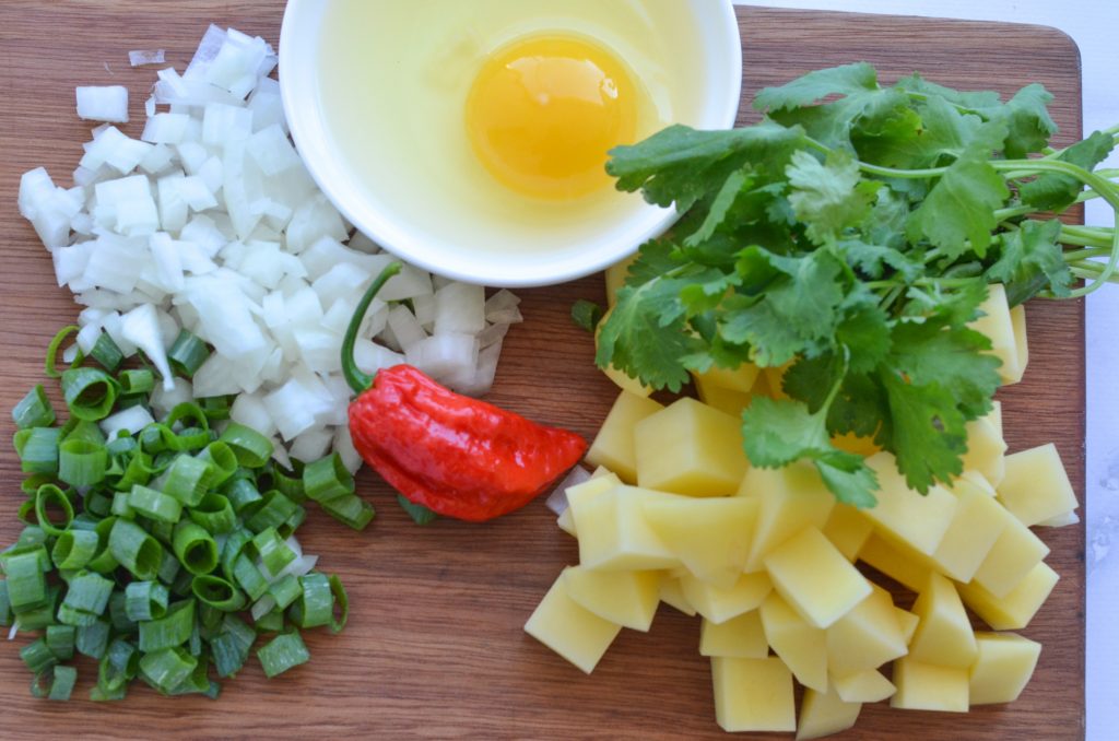 ingredients on a board for scrambled eggs and potatoes
