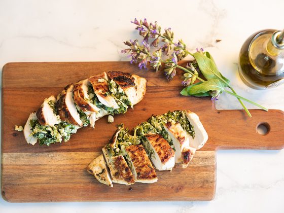 Spinach and ricotta Stuffed Chicken breast fillets served on a board with sage flowers