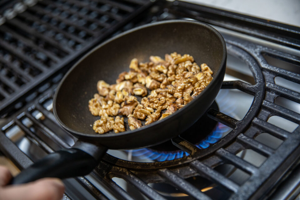 tossing walnut in a pan 